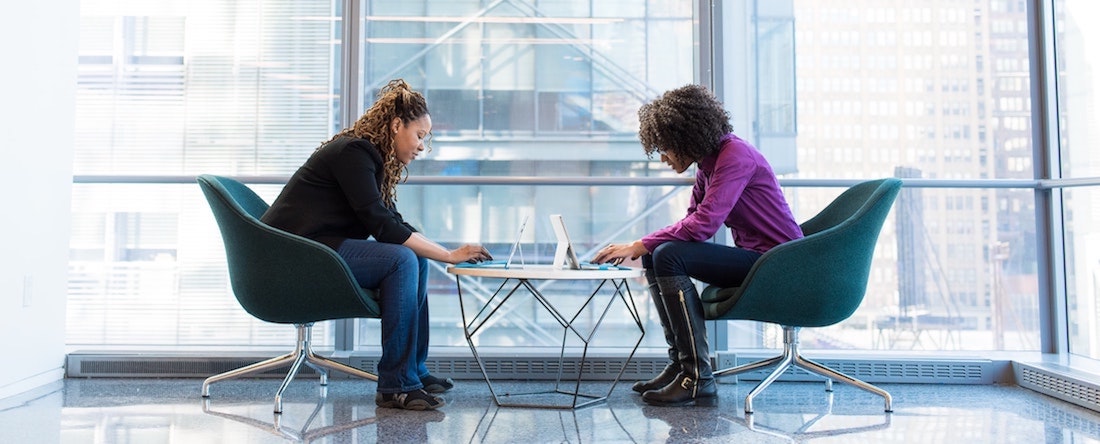 Two women working with their laptops